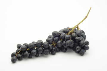 Racimo de uvas negras sobre fondo blanco