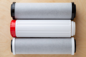 Water filters on a wooden background. New filters for water purification close-up.
