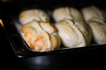 Baked pies on a tray in the oven