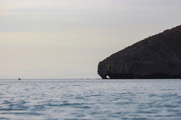 Fototapeta na wymiar Persona haciendo Kayak al atardecer en playa Balandra, Baja California Sur.