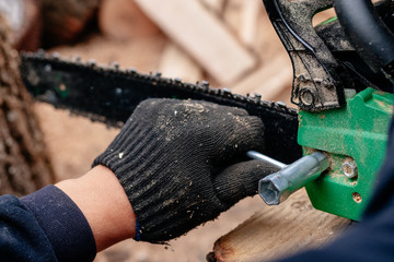 Professional technician working by repair service.Repairing chainsaw in repair shop.