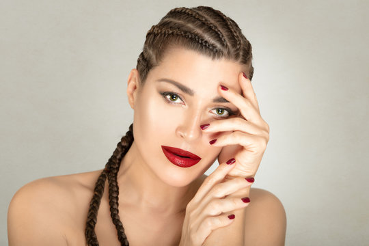 Appealing brunette with long braided hair and bright makeup lips manicure