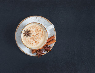Indian Masala chai tea. Traditional Indian hot drink with milk and spices on dark stone table background. Top view, flat lay. Copy space - obrazy, fototapety, plakaty