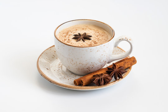 Indian Masala chai tea. Traditional Indian hot drink with milk and spices on white concrete background closeup.