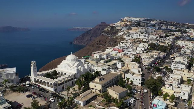 Aerial drone video of iconic picturesque main village of Fira built on a cliff with breathtaking views to Caldera and volcano, Santorini island, Cyclades, Greece