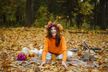 Happy girl throws yellow leaves up, autumn season.