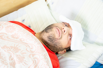 Arabic muslim man feeling sick and lying in bed