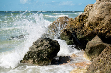 Waves crashing onto a rocky shore after a tropical storm on the Florida coast.