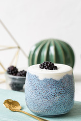 Fototapeta na wymiar Blue chia seed pudding with blackberries in a glass