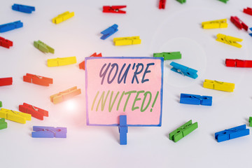 Text sign showing You Re Invited. Business photo text make a polite friendly request to someone go somewhere Colored clothespin papers empty reminder white floor background office