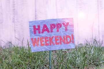 Text sign showing Happy Weekend. Business photo showcasing something nice has happened or they feel satisfied with life Plain empty paper attached to a stick and placed in the green grassy land