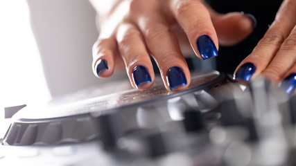 female DeeJay hands on a DJ modern console