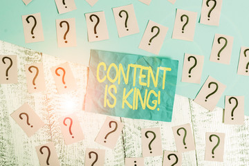 Handwriting text writing Content Is King. Conceptual photo marketing focused growing visibility non paid search results Scribbled and crumbling papers with thick cardboard above wooden table