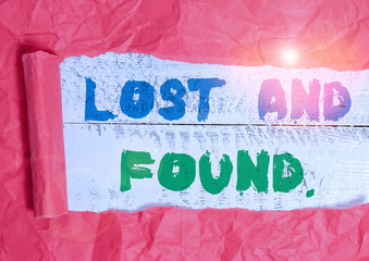 Conceptual hand writing showing Lost And Found. Concept meaning a place where lost items are stored until they reclaimed Cardboard which is torn placed above a wooden classic table