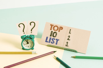 Conceptual hand writing showing Top 10 List. Concept meaning the ten most important or successful items in a particular list Mini size alarm clock beside stationary on pastel backdrop