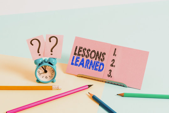Conceptual hand writing showing Lessons Learned. Concept meaning experiences distilled project that should actively taken Mini size alarm clock beside stationary on pastel backdrop