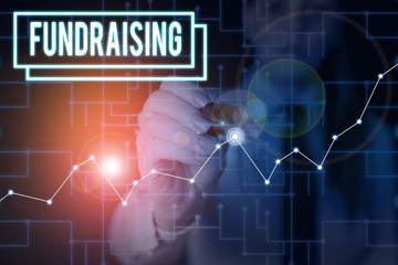 Word writing text Fundraising. Business photo showcasing seeking to generate financial support for charity or cause Woman wear formal work suit present presentation using smart latest device