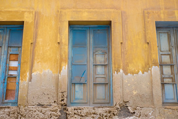 Fototapeta na wymiar Three pale blue windows in an old house.