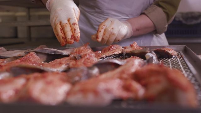 Marinating Raw Fish Fillets by Hand at Industrial Seafood Factory