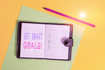 Text sign showing Set Smart Goals. Business photo showcasing list to clarify your ideas focus efforts use time wisely Dark leather private locked diary striped sheets marker colored background