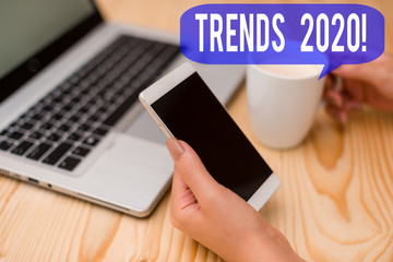 Text sign showing Trends 2020. Business photo showcasing general direction in which something is developing or changing woman laptop computer smartphone mug office supplies technological devices