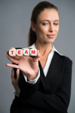 businesswoman holding cubes with the word "TEAM"