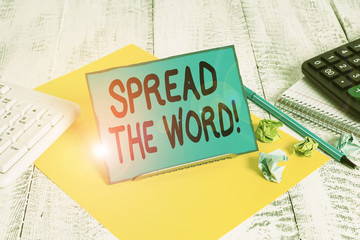 Conceptual hand writing showing Spread The Word. Concept meaning share the information or news using social media Notepaper on wire in between computer keyboard and sheets