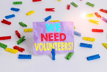 Writing note showing We Need Volunteers. Business concept for someone who does work without being paid for it Colored clothespin papers empty reminder white floor background office