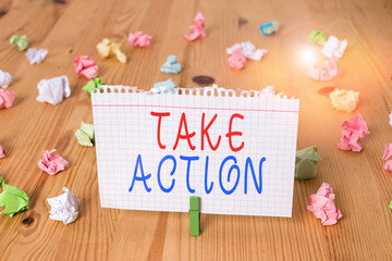 Text sign showing Take Action. Business photo text to do somethingoract in order to get a particular result Colored crumpled papers empty reminder wooden floor background clothespin