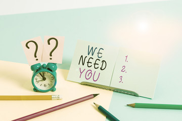 Writing note showing We Need You. Business concept for to fulfill the needs of the assignment duty or obligation Mini size alarm clock beside stationary on pastel backdrop