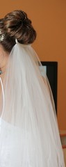 Soft white satin veil flowing down from a bride's hair