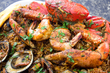 Close up of seafood with rice in a black marble background. Delicious ecuadorian dish with crab, shrimps, mussels, fried banana and rice.