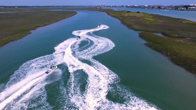 Drone Aerial Slow Motion Jet Skis driving through salt marsh