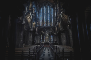 GLASGOW, SCOTLAND, DECEMBER 16, 2018: Magnificent perspective view of interiors of Glasgow Cathedral, known as High Kirk or St. Mungo, with huge stained glasses. Scottish Gothic architecture.