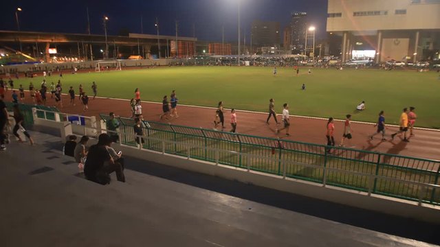 Time lapse of people running on running track .