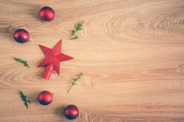 Christmas background - flat lay of red christmas balls, pine cones and fir branches over wooden background. Copy space.