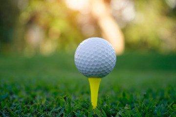 Golf ball on tee in beautiful golf course