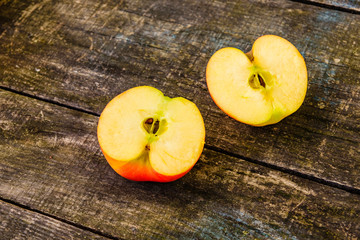 Halved ripe apple on a wooden table.