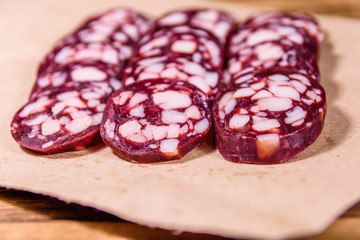 Sliced salami sausage on a brown wrapping paper