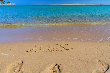 New year 2020. Inscription on a sandy beach. Tropical celebration concept