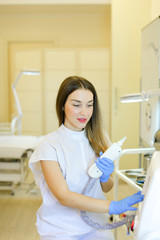 Young permanent makeup artist sitting with laser removal device at beauty salon.