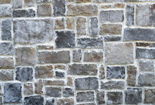 Decorative stone wall with white seams. Texture background.