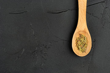 Dry rosemary in a spoon
