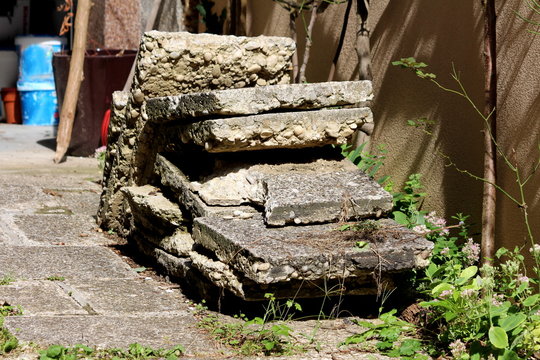 Large Stone And Concrete Tiles Taken Out Of Family House Backyard During Reconstruction Left On Driveway To Be Taken For Recycling On Warm Sunny Summer Day