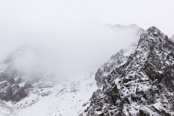 landscape of winter rocky mountains with fog