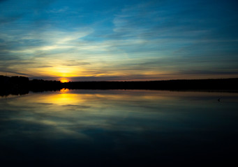 Fototapeta na wymiar Beautiful sunset reflected in the lake. Scenic landscape