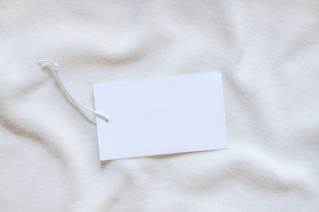 Price tag, blank brand label on white knitting clothes  