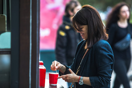 Woman Put Sugar In Red Paper Coffee Cup