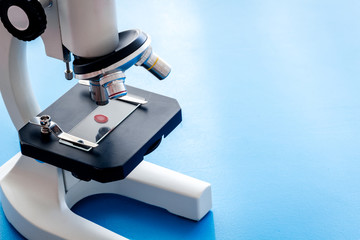 Blood testing. Samples viewing undermicroscope on blue background top view copy space