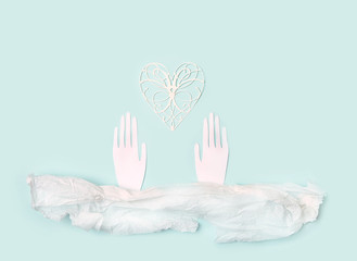 creative minimalistic concept design. paper texture, paper hands and heart. hands and heart on pastel blue background. concept of romantic, care and kindness, love, charity, helping. copy space